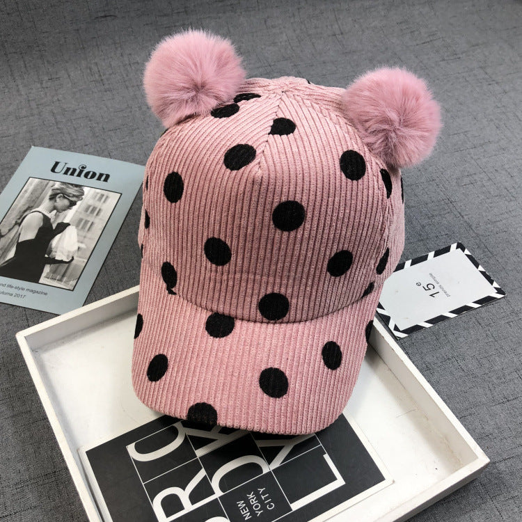 Zwei flauschige Bommeln aus echtem oder Kunstkaninchenfell verleihen dem Hut einen verspielten und eleganten Look.