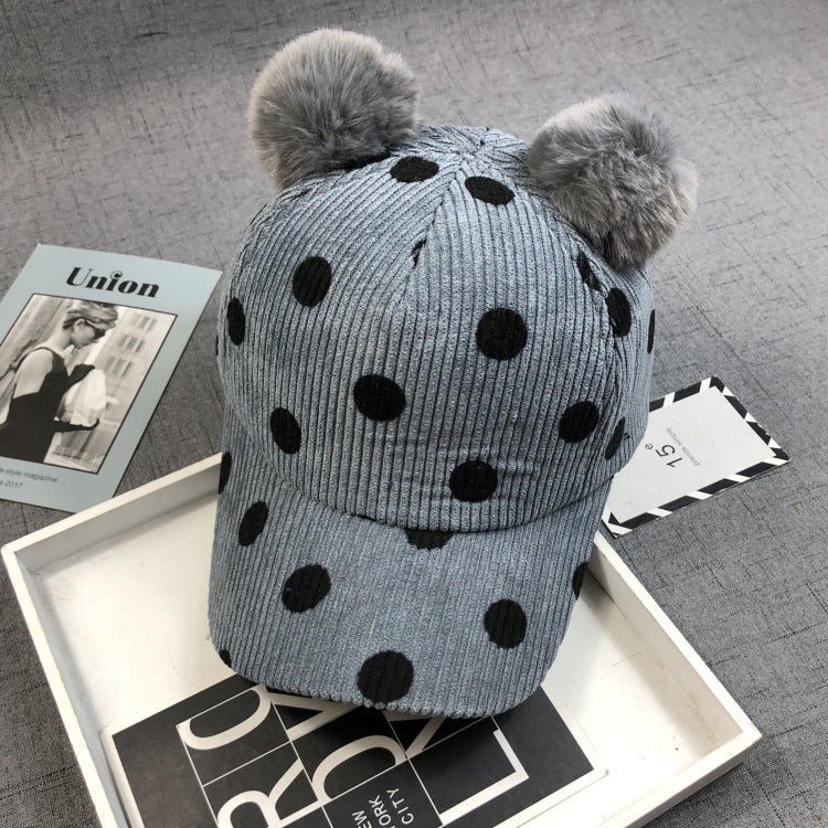 Zwei flauschige Bommeln aus echtem oder Kunstkaninchenfell verleihen dem Hut einen verspielten und eleganten Look.