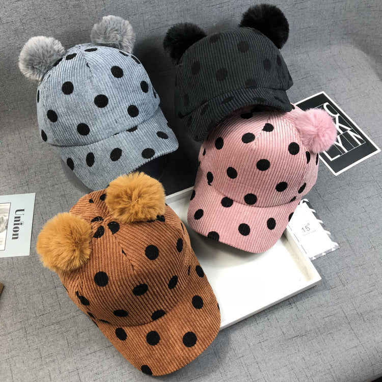 Zwei flauschige Bommeln aus echtem oder Kunstkaninchenfell verleihen dem Hut einen verspielten und eleganten Look.